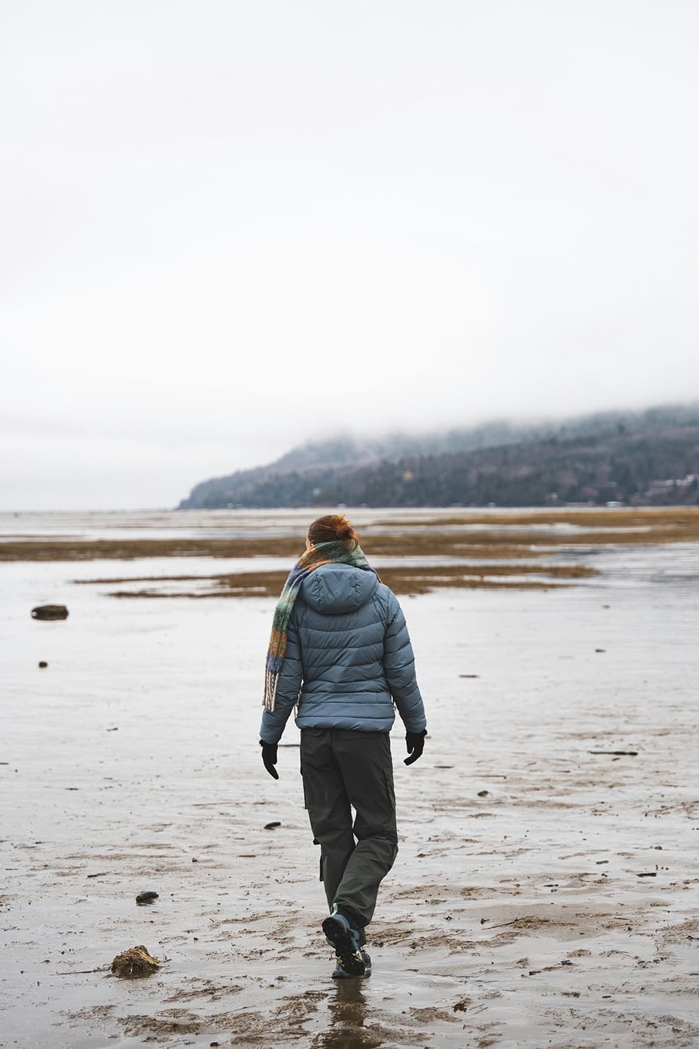 Person walking on a foggy beach